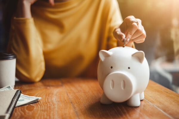Woman,Hand,Putting,Money,Coin,Into,Piggy,For,Saving,Money