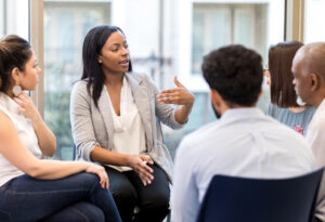 Skilled helping professional leads a group therapy session.