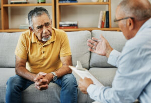 Helping professional counseling an older man.